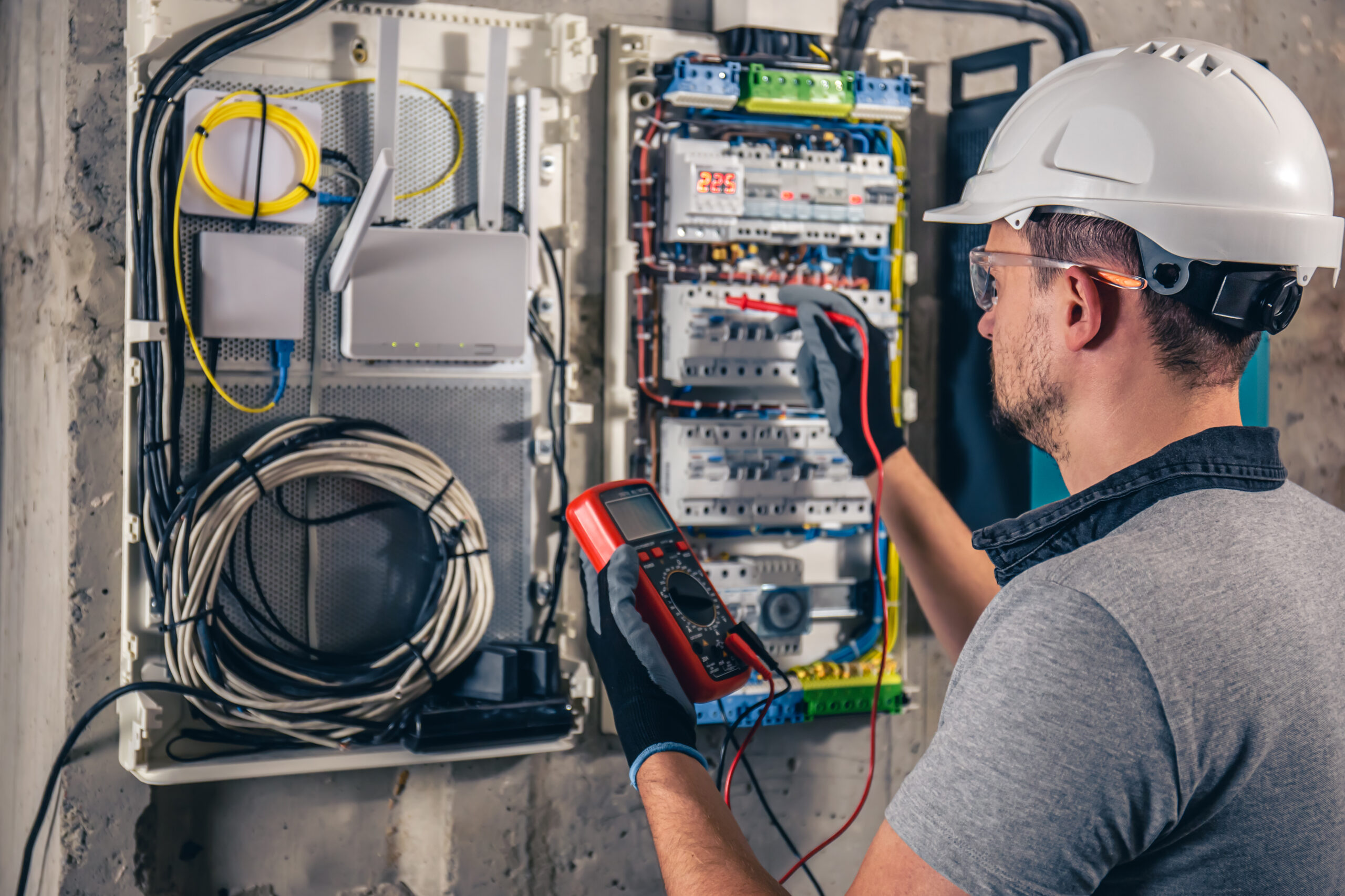 man electrical technician working switchboard with fuses 1 scaled