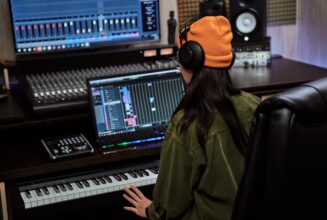 young-woman-female-artist-looking-focused-while-playing-keyboard-synthesizer-sitting-recording-min