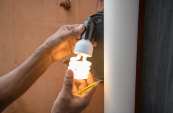 electrician-change-light-bulb-house-exterior-wall-lamp-min