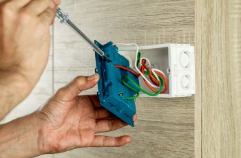 remove-power-electric-plug-socket-from-outlet-box-wooden-wall-check-voltage-with-screwdriver-min